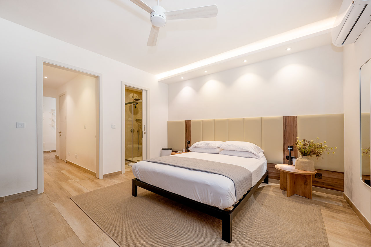 Main bedroom with upholstered headboard and en-suite