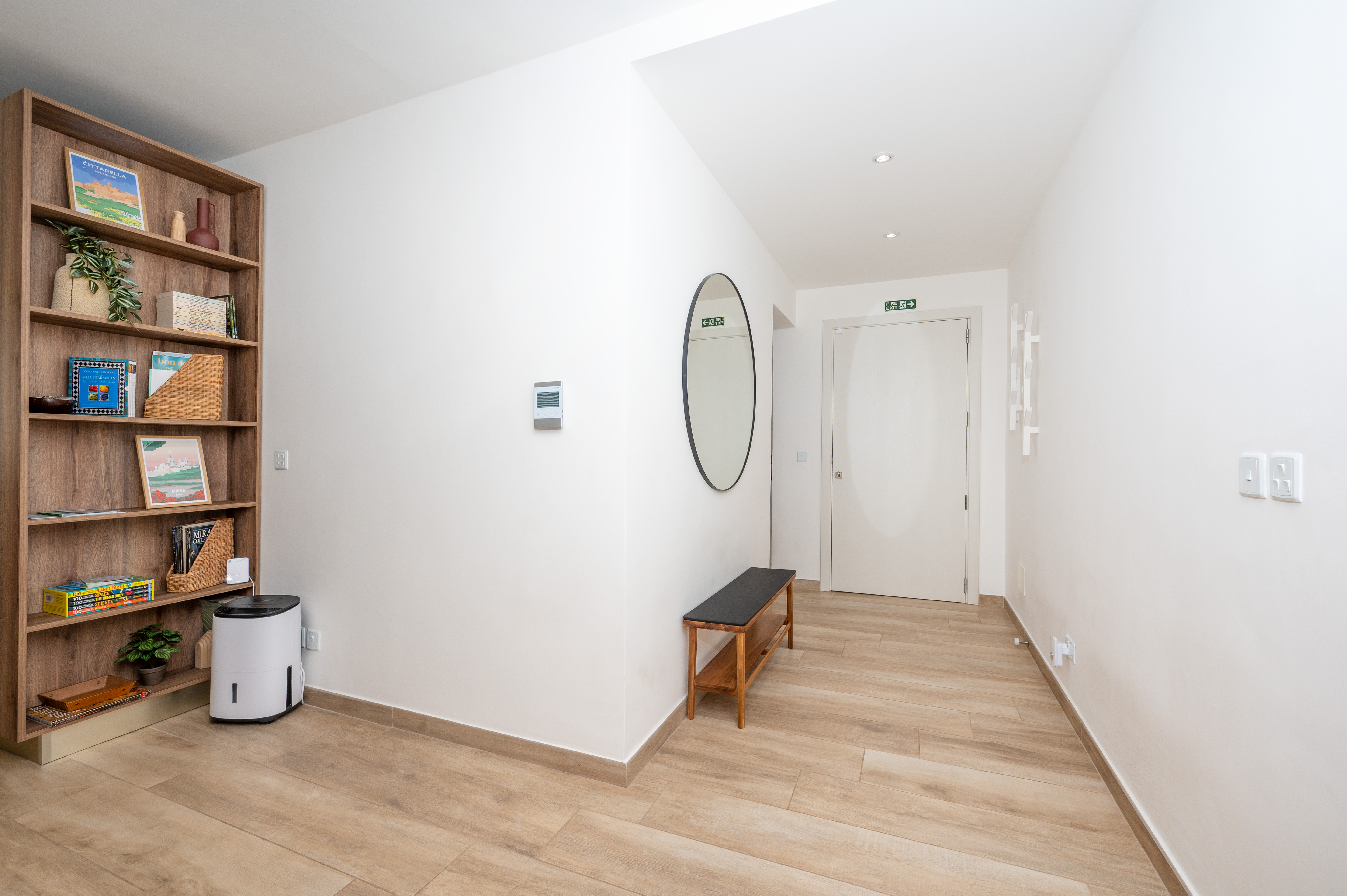 Entrance hallway with bookshelf and round mirror